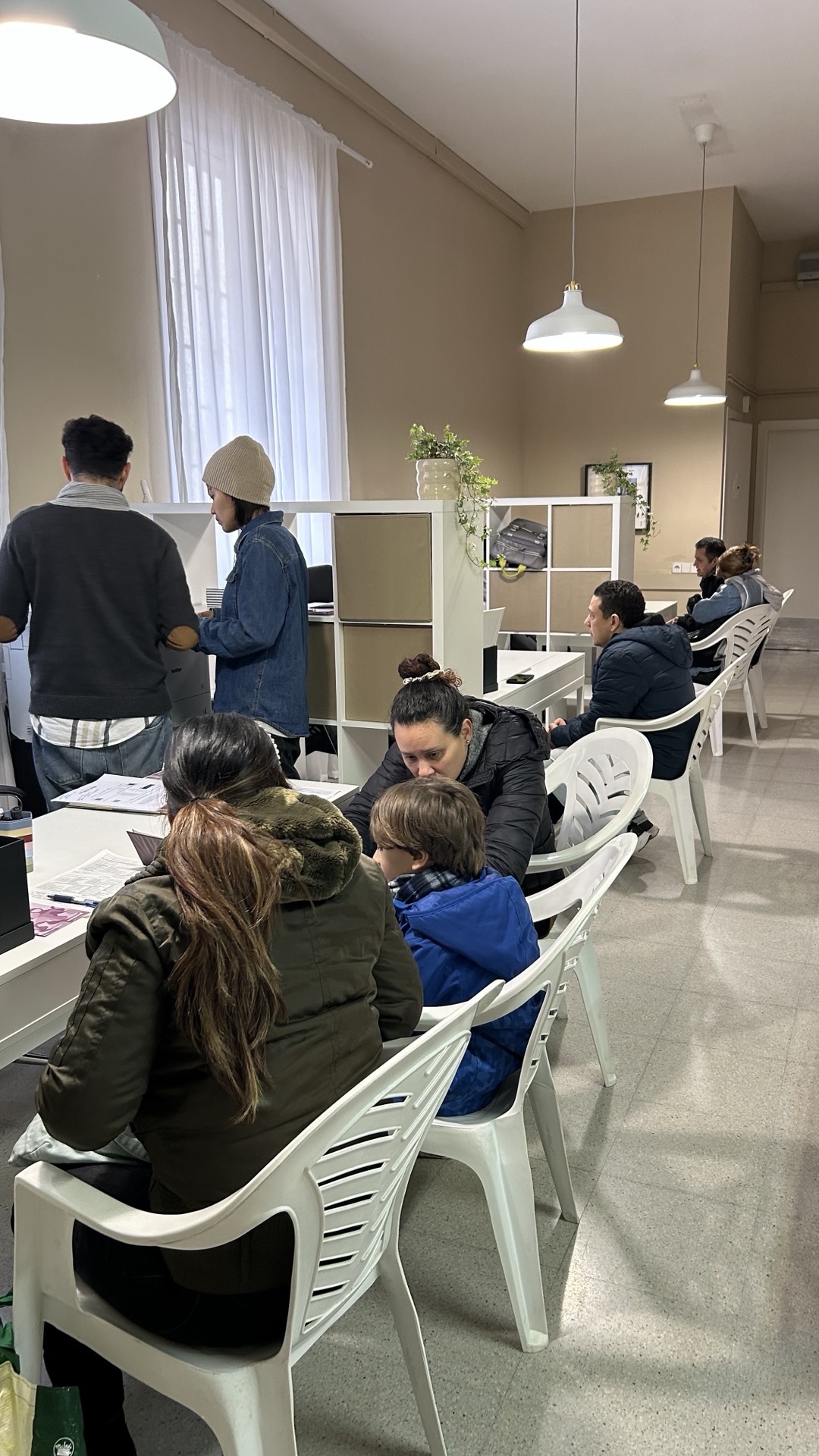 Personas migrantes recibiendo atención y orientación en la oficina
